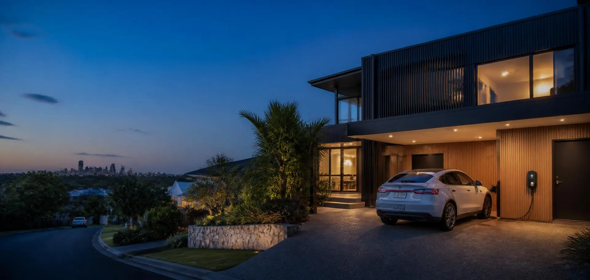 Contemporary Brisbane home at dusk with an electric car charging in the driveway