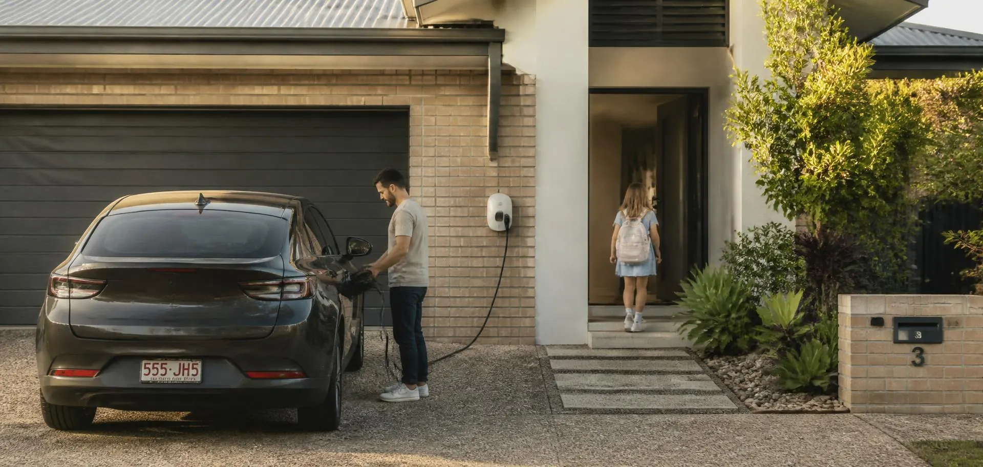 Family arriving home at a Brisbane house in the late afternoon and plugging in their electric car